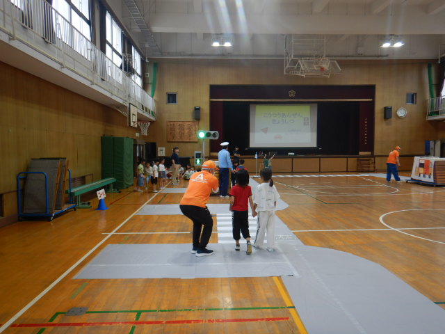 体育館内に信号機や横断歩道など模擬道路を設置し、児童が安全に歩行できるよう指導する