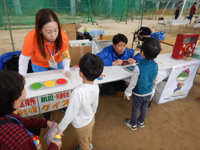 信号のパネルを使って子どもたちに信号の意味を説明する区役所職員
