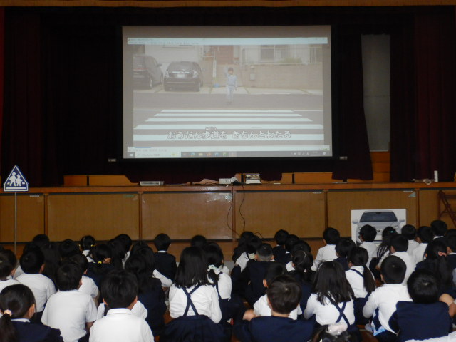 交通安全のDVDを映写して学習する児童