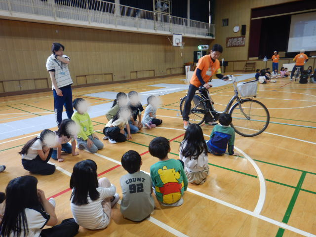 児童に自転車の点検の仕方を説明する区役所職員
