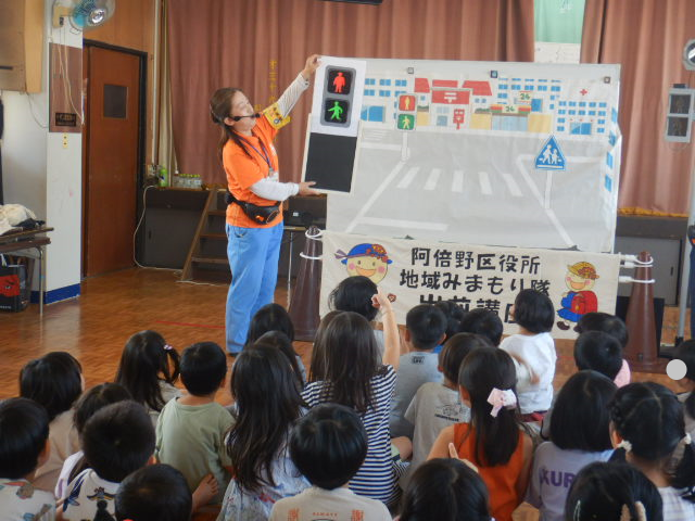 色のついていない歩行者信号の模型を見せて園児に色を答えてもらう