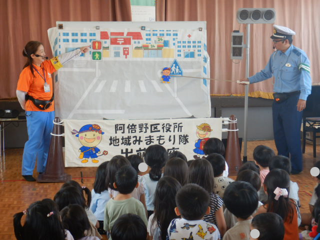 横断歩道の安全なわたり方を絵図を使って説明する警察官