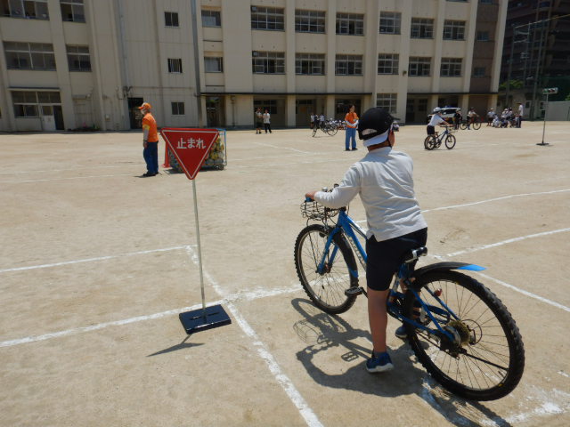 自転車に乗った4年生が止まれの標識で確実に止まり、左右の安全確認をする様子