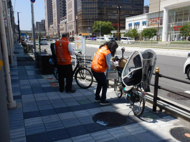 阿倍野筋歩道の放置自転車に啓発札を取り付ける
