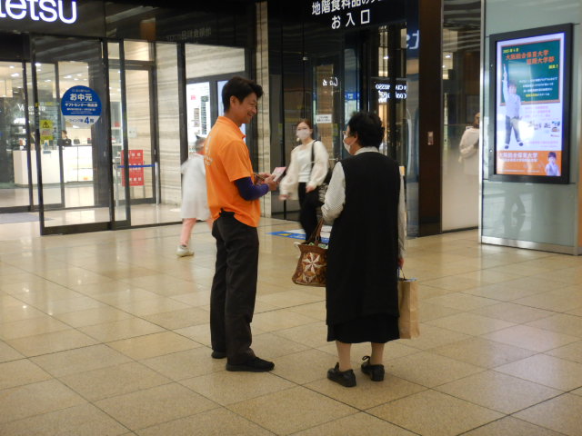 駅利用者に啓発物品を配付して注意喚起する区役所職員