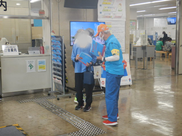 来庁者に啓発物品を配付して注意喚起する区役所職員