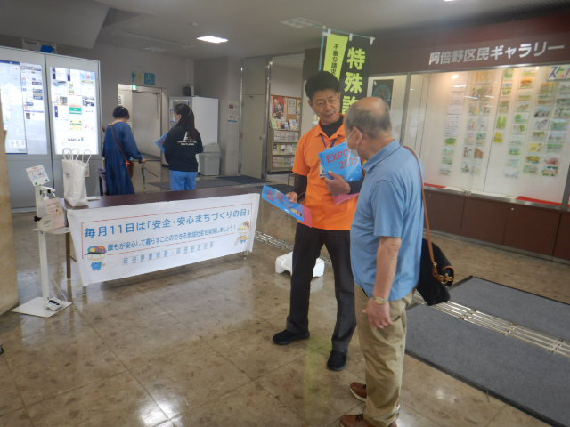 区役所玄関ロビーで来庁者に特殊詐欺に注意してと呼びかける区役所職員