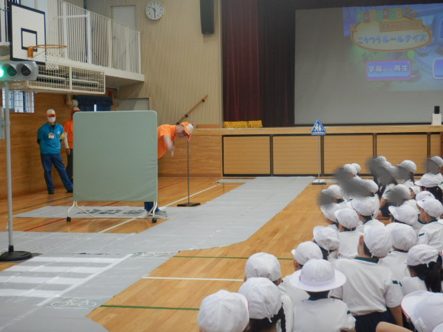 講堂に準備した模擬道路で区役所職員が安全な歩き方の見本を見せる