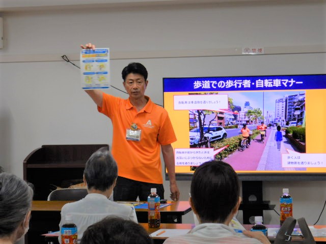 モニターを使って自転車のルールやマナーについて説明する区役所職員