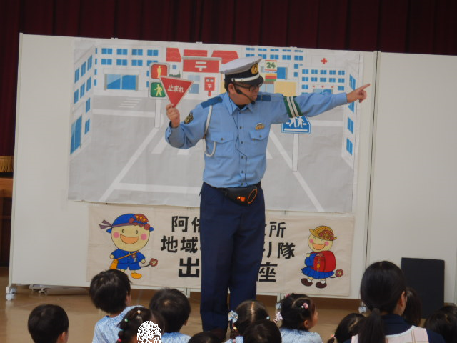 止まれの標識の説明をする警察官