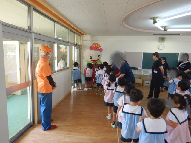 会場の出口で待つあべのんにタッチして部屋に戻る園児