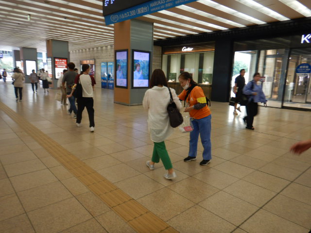 近鉄大阪阿部野橋駅コンコースで利用者に女性被害防止を呼びかける区役所職員
