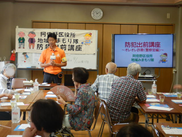 食事サービスの参加者に特殊詐欺について注意を呼びかける区役所職員