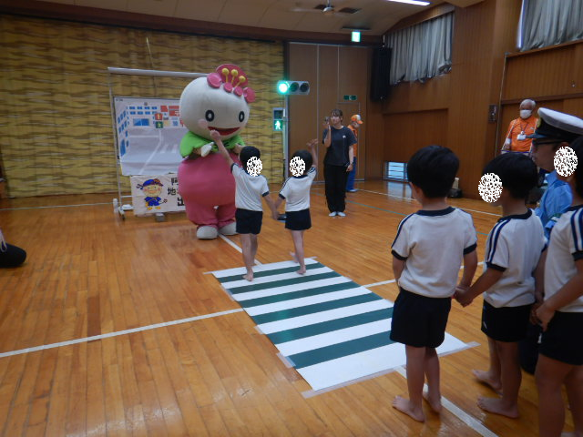 横断歩道を安全にわたり、あべのんとハイタッチをする園児