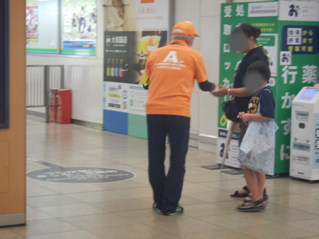 駅利用者に特殊詐欺被害防止を呼びかける区役所職員