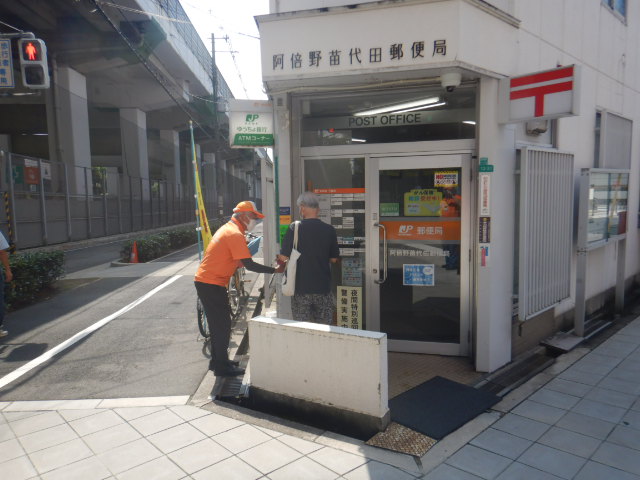 阿倍野苗代田郵便局前で利用者に特殊詐欺被害防止を呼びかける区役所職員