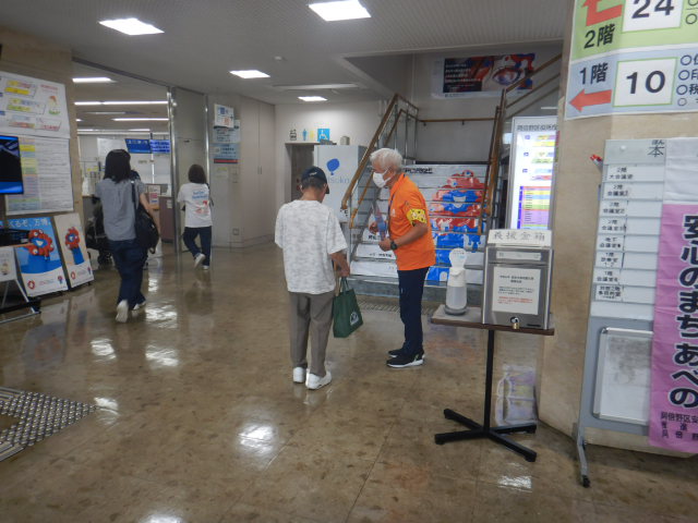 利用者に特殊詐欺被害防止を呼びかける区役所職員
