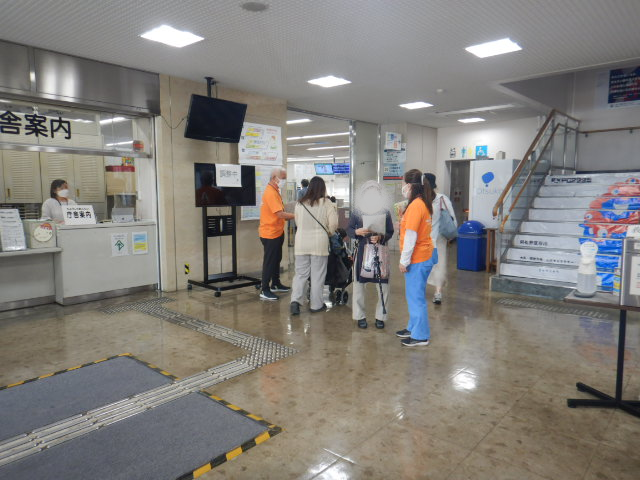 玄関ロビーで来庁者に注意喚起する区役所職員