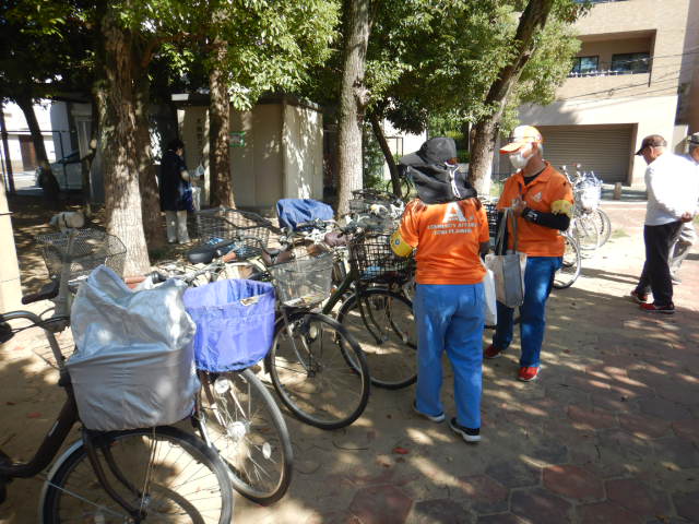 キャンペーン参加者の自転車前かご啓発物品を配付する区役所職員