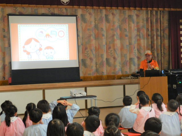 スクリーンに映写した防犯紙芝居を観賞する園児たち