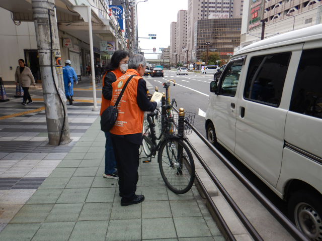 放置自転車に啓発札を取りつける参加者