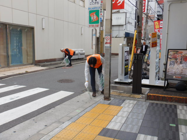 路上の吸い殻やごみを拾い清掃活動をする参加者