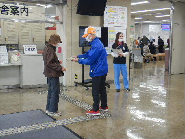 来庁者に啓発物品を配付して注意喚起する区役所職員