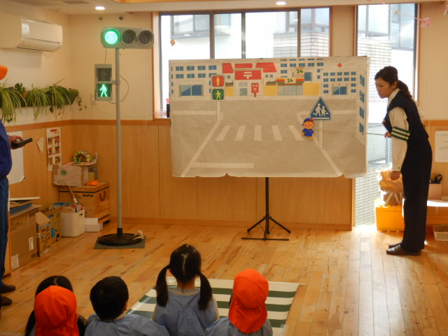 横断歩道の絵図を使って安全なわたり方を説明する警察官