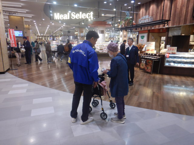 スーパー利用者に特殊詐欺被害防止を呼びかける区役所職員