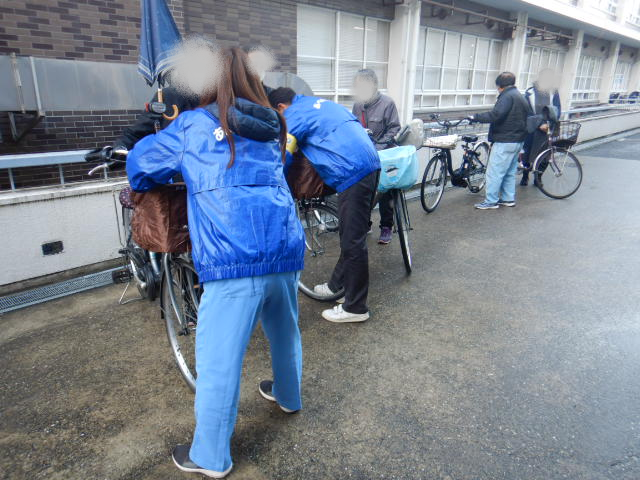 キャンペーンに来られた順にひったくり防止カバーの取りつけをおこなう区役所職員