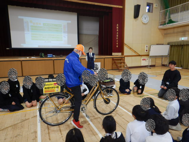 4年生に自転車の点検の仕方を説明する区役所職員