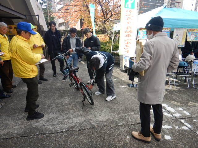 来庁者の自転車を点検する専門学生
