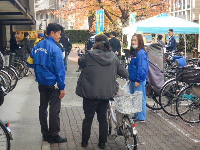 来庁者に自転車の無料点検を案内する区役所職員