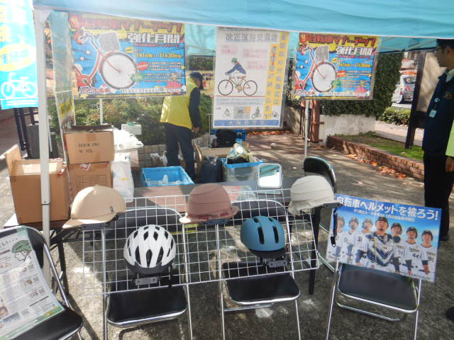 庁舎前駐輪場の一角でいろいろな自転車用ヘルメットを展示する