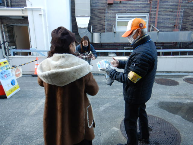 キャンペーン参加者に啓発物品を配付して注意喚起する区役所職員