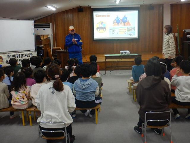 地域みまもり隊をスクリーンに映写して紹介する