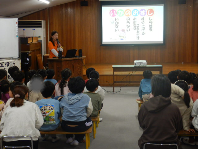 防犯標語「いかのおすし」をスクリーンに映写して説明する