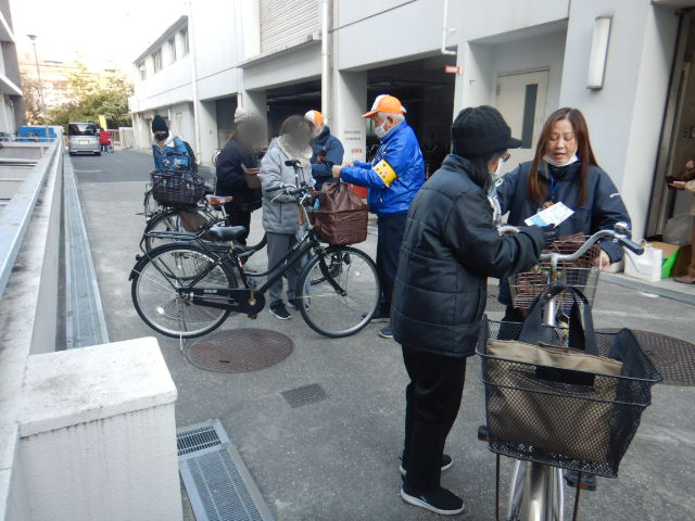 キャンペーン参加者に啓発物品を配付して注意喚起する区役所職員