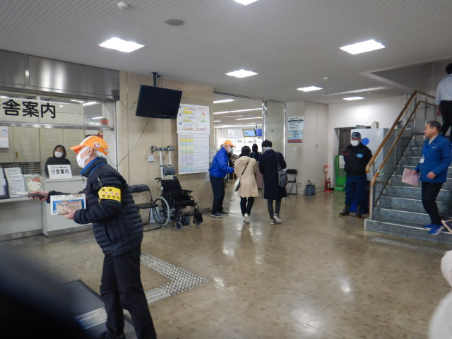 来庁者に啓発物品を配付して注意喚起する区役所職員