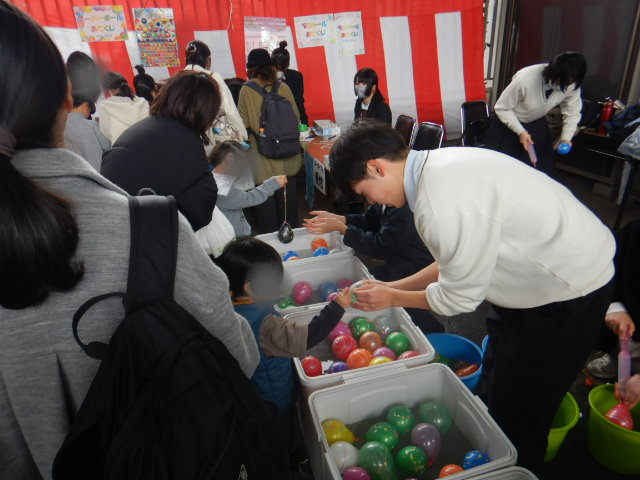 明浄学院高校生によるヨーヨー釣りを楽しむ子ども達