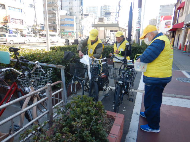昭和町駅周辺の駐輪場近くにある放置自転車に啓発札を取りつけるサイクルサポーター