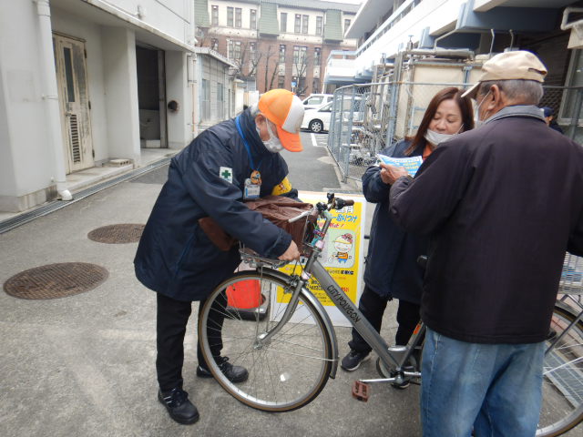 キャンペーン参加者に自転車のルールについて注意喚起する区役所職員
