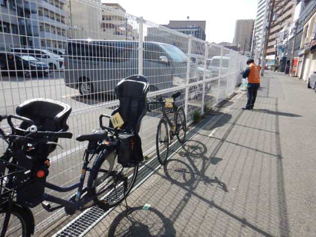 道路上の放置自転車に啓発札を取りつける啓発活動の参加者