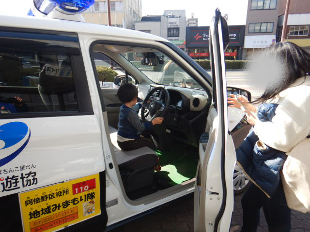 青色防犯パトロールカーに体験乗車する子ども