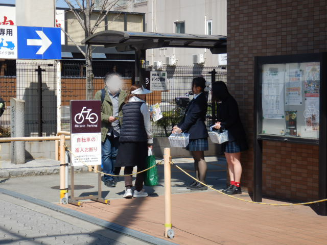 スーパー利用者に啓発物品を配付する高校生