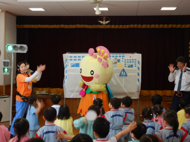 あべのんと一緒に交通安全ストップ体操をする園児と区役所職員