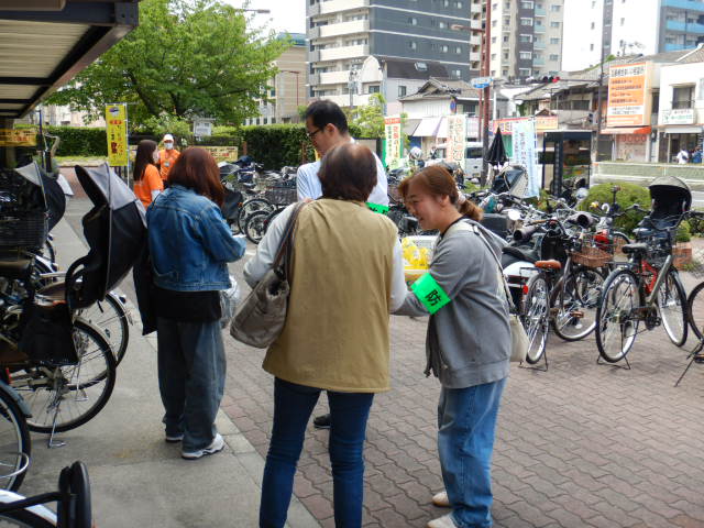 区役所前駐輪場で特殊詐欺被害防止啓発をおこなう阿倍野警察署員と区役所職員