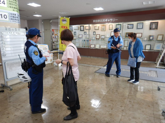来庁者に特殊詐欺に注意してと呼びかける警察官