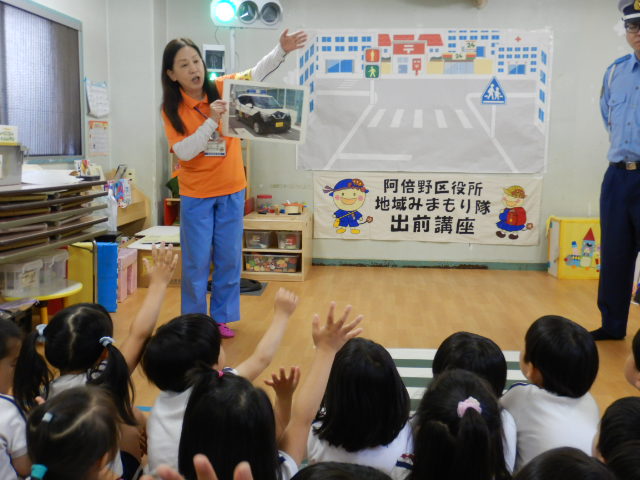 園児に青パトの写真を見せて自己紹介をする区役所職員