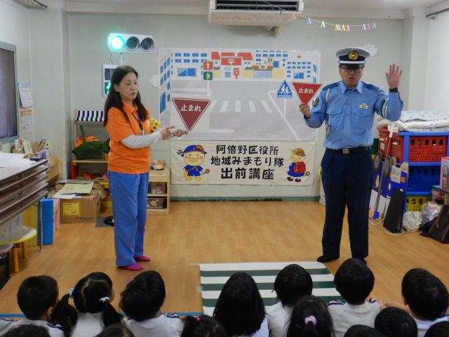 園児に止まれの標識を見せて説明をする警察官